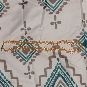 Peach colored rice pearl necklace.